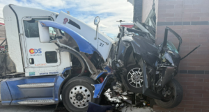 Semitrailer crushes vehicle against building in Littleton