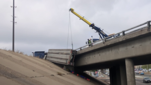 Semitruck dangling over I-70 bridge near West Colfax leads to traffic delays